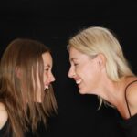 A mother and daughter enjoying a happy and playful moment together indoors.